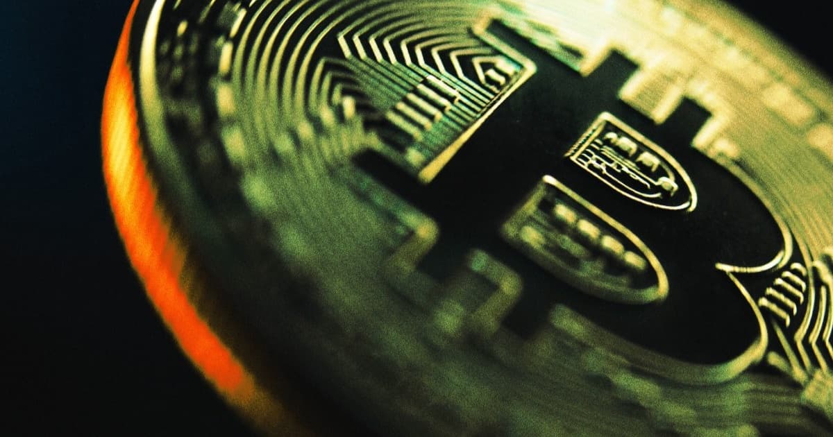 Fotografi Bitcoin membesar memudar ke dalam kegelapan, simbol penurunan harga.