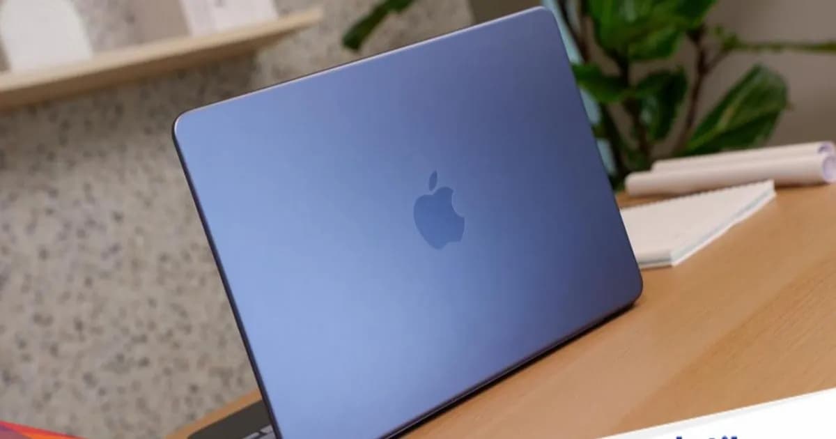 MacBook Neo dengan layar menyala di atas meja kayu