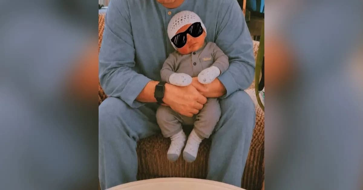 Ilustrasi foto hasil rekayasa AI yang menunjukkan seorang pria menggendong bayi palsu hasil manipulasi digital