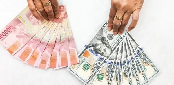 Petugas memperlihatkan lembaran uang dolar Amerika Serikat dan rupiah di gerai penukaran mata uang asing PT Ayu Masagung, Jakarta Pusat, Kamis (23/4/2026).