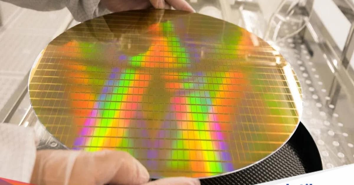 Wafer chip TSMC dengan logo perusahaan di atas latar belakang biru