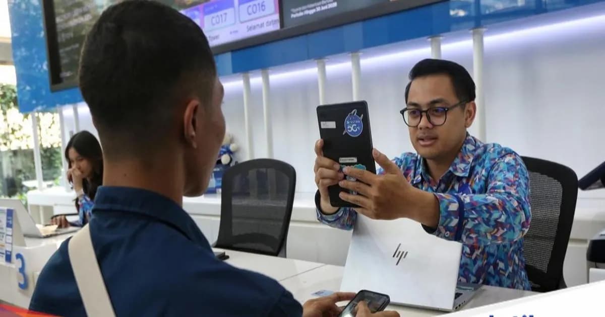 Petugas membantu pelanggan melakukan registrasi biometrik wajah untuk aktivasi kartu SIM baru di XL Center.